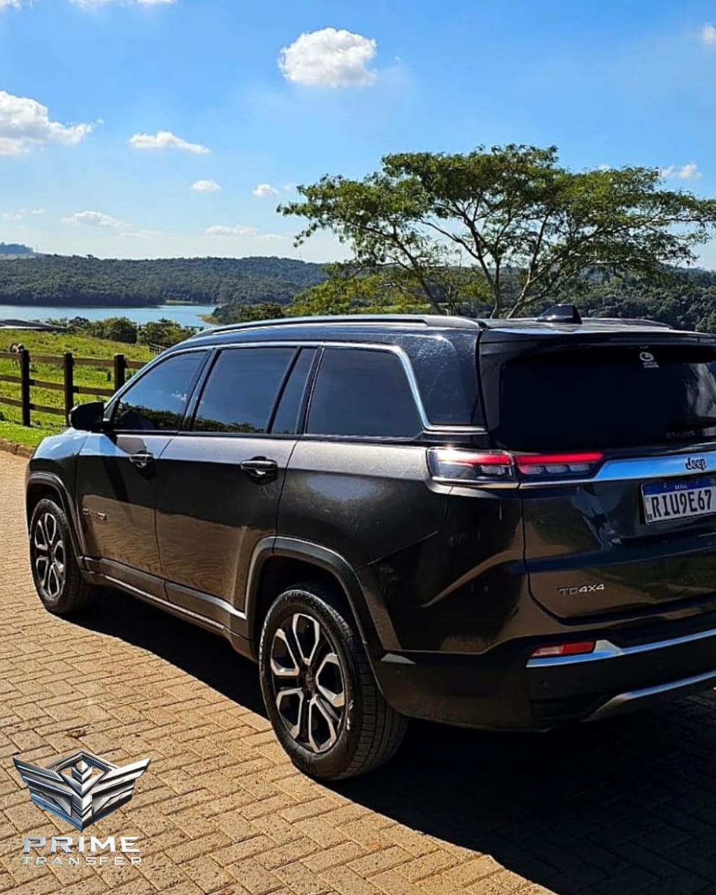 SUV Jeep Commander da Prime Transfer estacionada em um mirante com vista para o campo